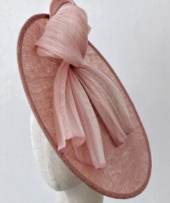 Plato tocado de sinamay rosa con lazada para invitada, Corinne.
