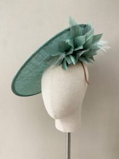 Tocado de sinamay con onda con plumas. Colocación mediante diadema. Invitada y madrina