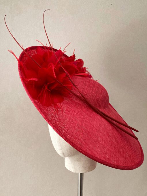 Pamela de sinamay con plumas y raquis para invitada. Se coloca con diadema y está disponible en tres colores.