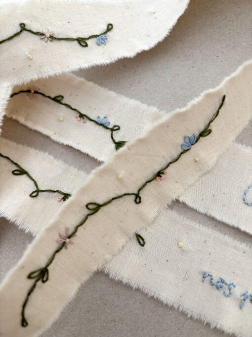 Cinta para ramo de novia con guirnalda bordada a mano. Los tonos empleados son naturales, perfectos para cualquier estilo de ramo. Personalízala con las iniciales o la fecha.