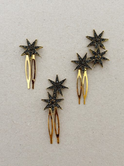 peinetas formadas por estrellas doradas que tienen piedras oscuras en su interior.